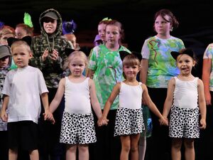 Kleine und große Schauspieler. Jungen und Mädchen stehen Hand in Hand nebeneinander. Alle in ihren individuellen Kostümen.