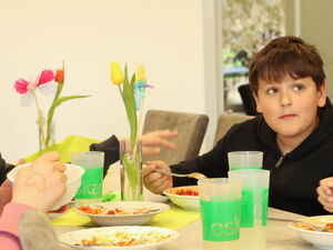 2 Mädchen, 2 Jungs am Tisch beim gemeinsamen Essen.