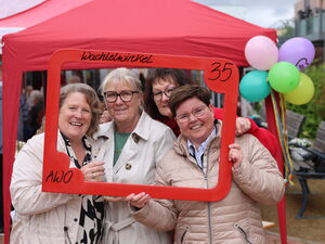 4 Frauen lächeln durch einen roten Bilderrahmen, den sie vor sich halten. In der oberen rechten Ecke steht eine 35.