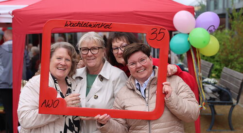 4 Frauen lächeln durch einen roten Bilderrahmen, den sie vor sich halten. In der oberen rechten Ecke steht eine 35.