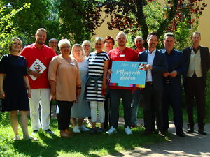 Draußen, Sonne scheint. Gruppenbild mit 13 Personen.