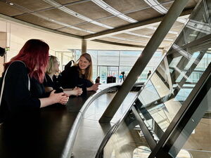 Glaskuppel Bundestag von innen. 3 Frauen stehen an der Brüstung die Einblick zum Plenarsaal gibt.