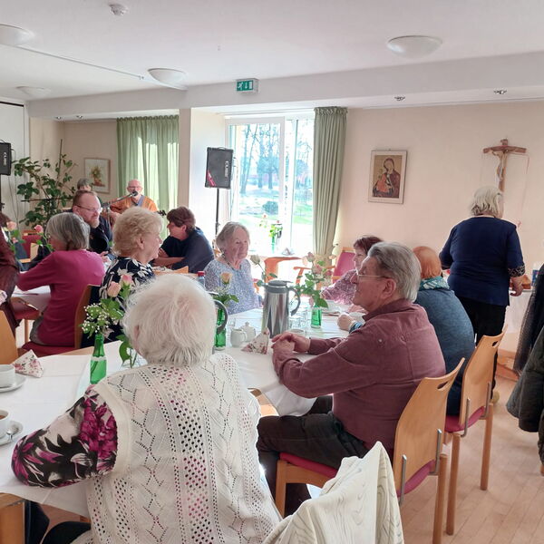 Kaffeetafeln an denen größtenteils ältere Menschen sitzen.
