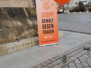 Auf dem Alten Markt, Orangener Luftballon und ein orangenes Rollup mit einer angedruckten Handfläche und dem Text. "Stopp Gewalt Gegen Frauen"