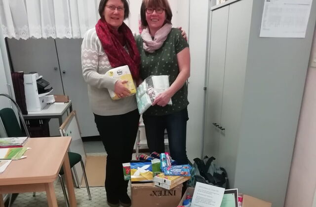 2 Frauen vor einem Stapel Spenden