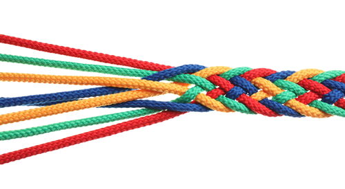 Rot, Grün, Gelb, Blau Fäden die geflechtet sind.