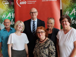 Gruppenfoto: 2 Männer, 4 Frauen. In der Mitte hinten, großer Mann in Anzug und Krawatte.