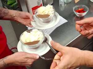 Dessert wird serviert. Vanilleeis auf Erdbeeren mit Sahne.