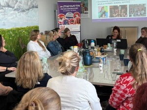 Büro Kindermut. Beratungsraum, Präsentation an der Wand. Voller Raum.
