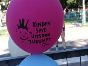 Lila Luftballon mit Aufdruck: Ein Kindergesicht und Text: Kinder sind unsere Zukunft.