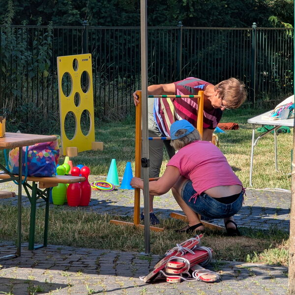 Kinderspielecke wird aufgebaut. Kegel, ein Wurfwand mit Löchern zum zielen.