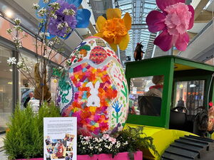 Im Sterncenter. Osterdekoration im Gang. Trecker mit Anhänger. Im Anhänger großes Osterei. Blumen und der Osterhase.