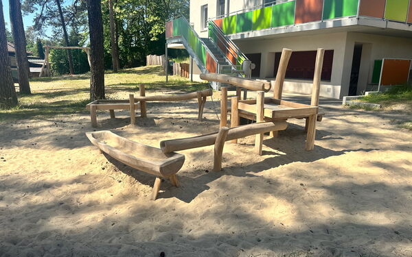 Wassermatschanlage. Eine Wasserpumpe Rohre und Wasserauffangbecken sind miteinander verknüpft. Aus Holz.