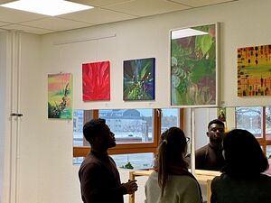5 Bilder an einer Wand. 3 Besucher schauen sich die Bilder an.