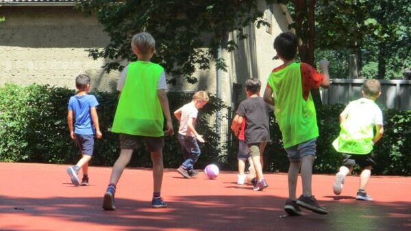 Zwei Fußballteams Kinder Jungs auf dem Sportplatz jagen dem Fußball hinterher.