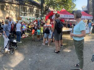 Ein Fest. Draußen. Menschen von jung bis alt. 2 AWO Pavillons. Schönes Wetter, Menschen tragen sommerliche Kleidung.