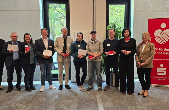 Gruppenfoto 10 Personen, 2. von rechts, Oberbürgermeisterin Aubel. Einige halten Briefe und rote Starschweine in der Hand.