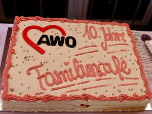 Große rechteckige Torte mit Verzierung das AWO Logo oben links und groß der Schriftzug: 10 Jahre Familiencafé.