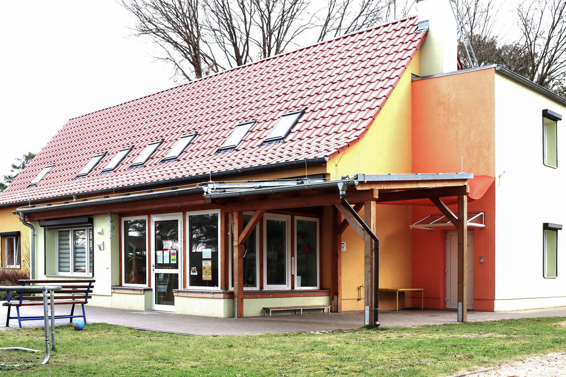 Kita Gebäude, davor eine Terrasse und Wiese.