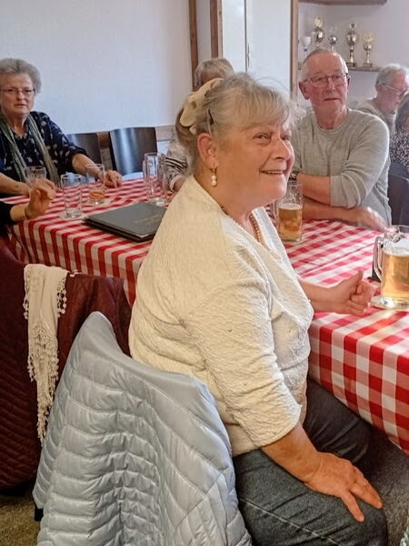 Menschen sitzen an Tischen mit ihren Getränken.