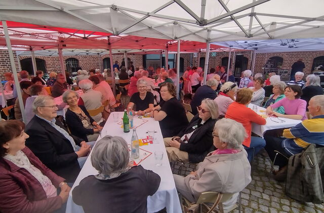 Festzelt, viele lange Tische. Viele Menschen sitzen an den Tischen. Größtenteils ältere Menschen.