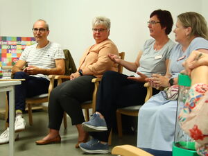 Ausschnitt Stuhlkreis, ein Mann, drei Frauen. Zweite Frau von rechts spricht.