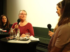 Gesprächsrunde. 2 Stehtische mit Wassergläser und Papieren. 2 Frauen frontal. 2 Frauen rechts am Bildrand.