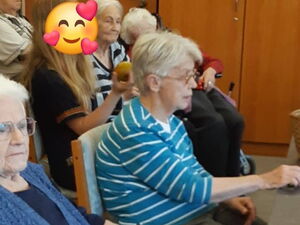 Senioren sitzen im Raum. Von der Seite.