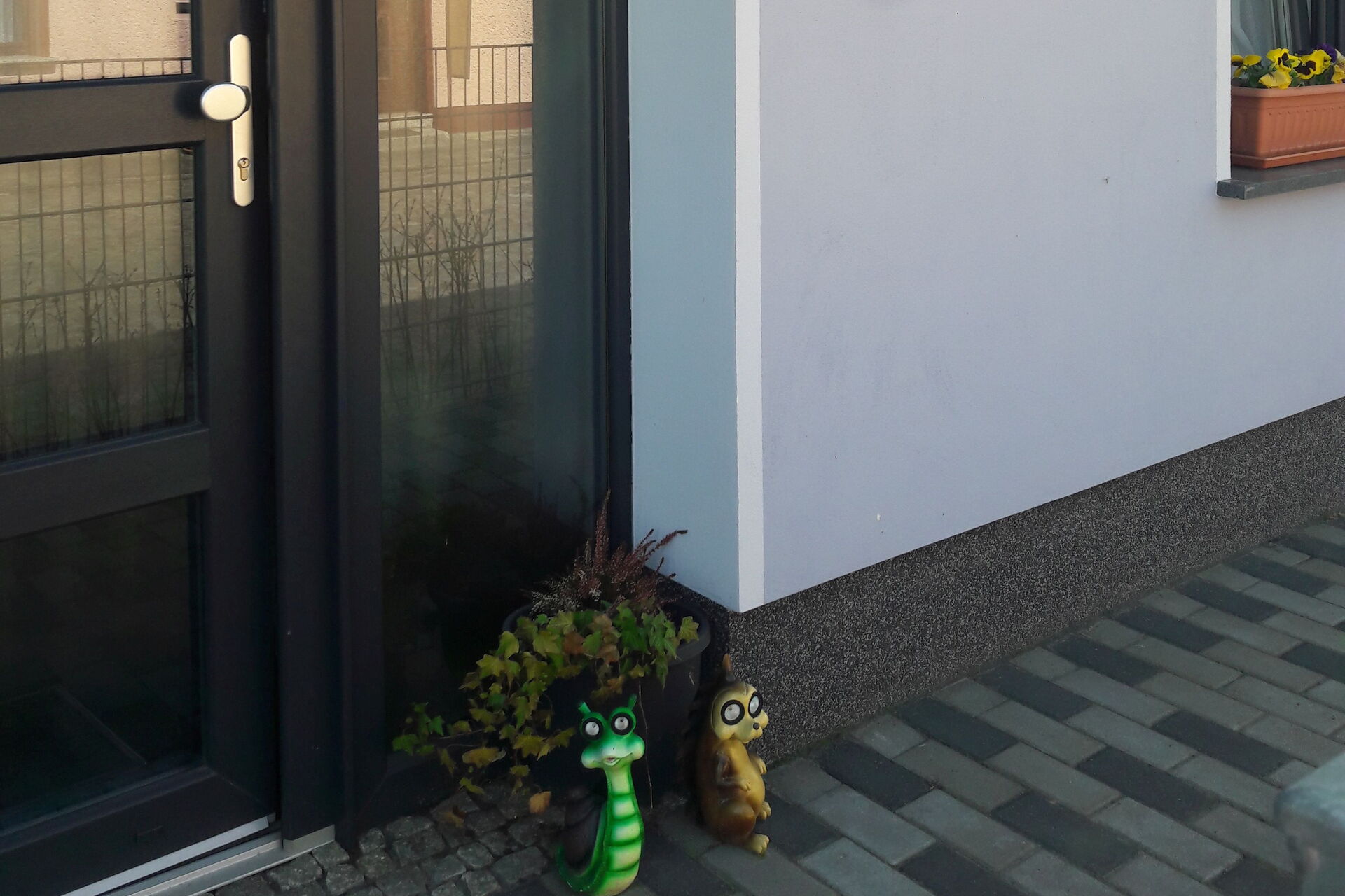 Eingangstür. An der Wand rechts neben der Tür die Klingel und die Hausnummer 12a weiter oben.