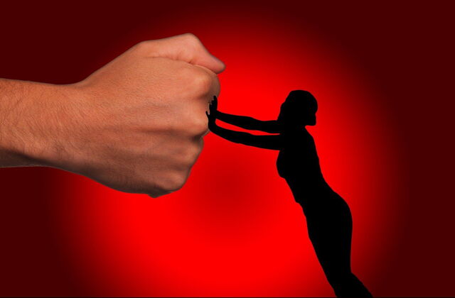Kleine Frauen Silhouette stemmt sich gegen eine große Faust eines Mannes. Abwehr.