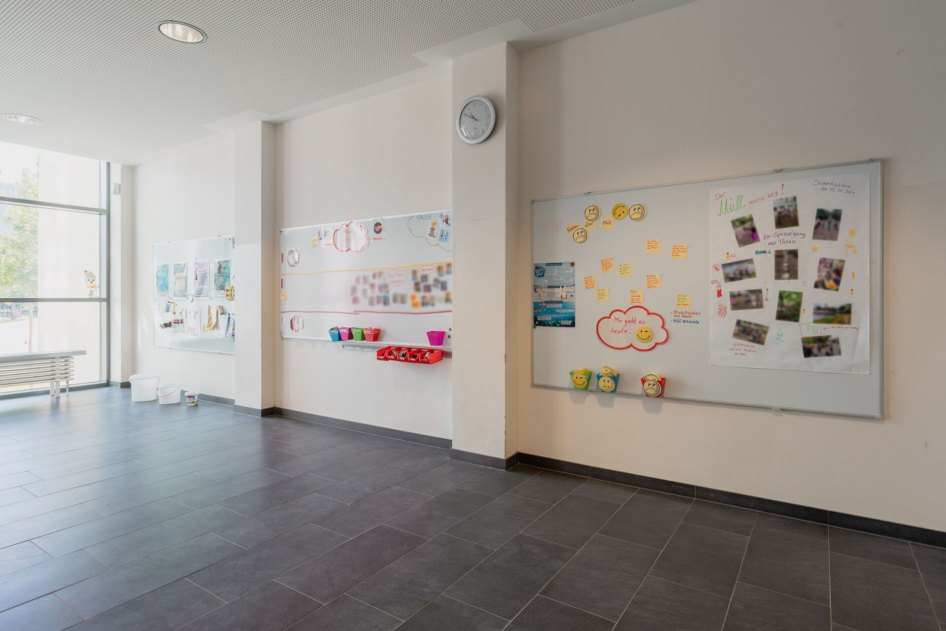 Großes Zimmer, drei große Magnettafeln an der Wand, Gelbe Smileys, eine Foto-Collage und Bilder sind an die Magnetwände geheftet.