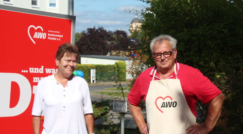 2 Personen vor einem AWO-Plakat