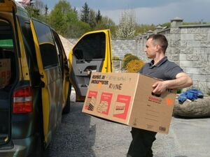Ein Foto von einem Mann neben einem Transporter, der einen Karton trägt