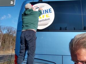 An einem Bus wir ein Schild mit der Aufschrift: Ukraine Hilfe angebracht