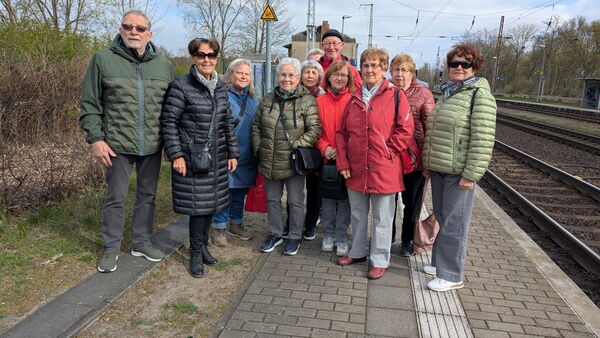 Gruppenbild. 11 Personen auf dem Bahnsteig.