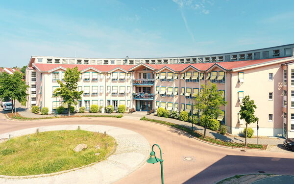 Kreisverkehr, dahinter großer Gebäudekomplex.