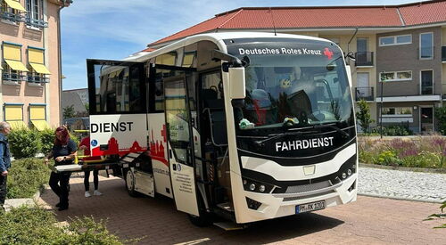 Reisebus von Deutschen Roten Kreuz steht vor Seniorenzentrum.