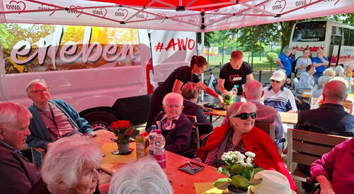 Roter AWO-Pavillon unter dem Senioren sitzen.