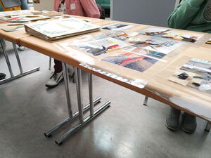 Infotisch mit Fotos, die auf Barrieren im Alltag aufmerksam machen.