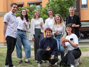 Gruppenbild: ein Mann und 7 Frauen. Draußen. Lockeres, fröhliches Gruppenfoto.