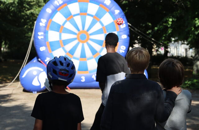 Große aufblasbarer Dartscheibe auf die mit mit Fußball geschossen wird.  Ein Ball klebt rechts außen an der Dartscheibe.