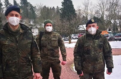 Draußen, es liegt Schnee, die Wege sind geräumt. Drei Soldaten - ein Obermaat und zwei Hauptgefreite des Seebataillons in Eckernförde mit FFP 2 Masken.