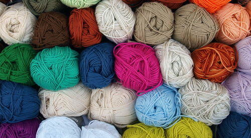 Viele farbige Wollknäule grün, mint, beige, blau, pink, orange, lila, braun