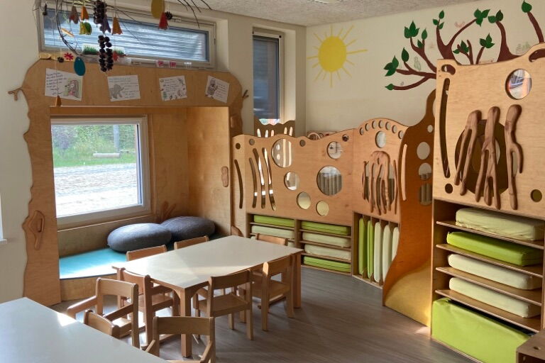 Raum mit kleinen Tischen und Stühlen. Möbel aus Holz.