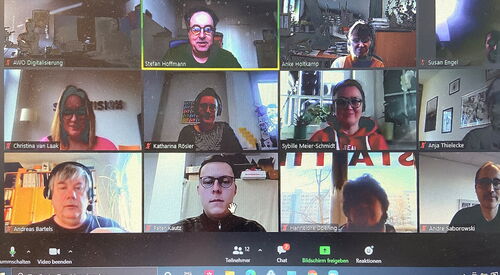 PC Bildschirm Screenshot von einer Videokonferenz. 12 Teilnehmer mit Namen Beschriftet.