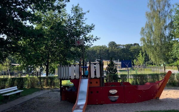 Spielplatz, Klettergerüst mit Rutsche im Sandkasten. Das Klettergerüst sieht aus wie ein Schiff.