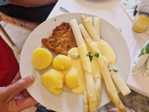 Mittag. Teller mit Schnitzel, Spargel und Kartoffeln.