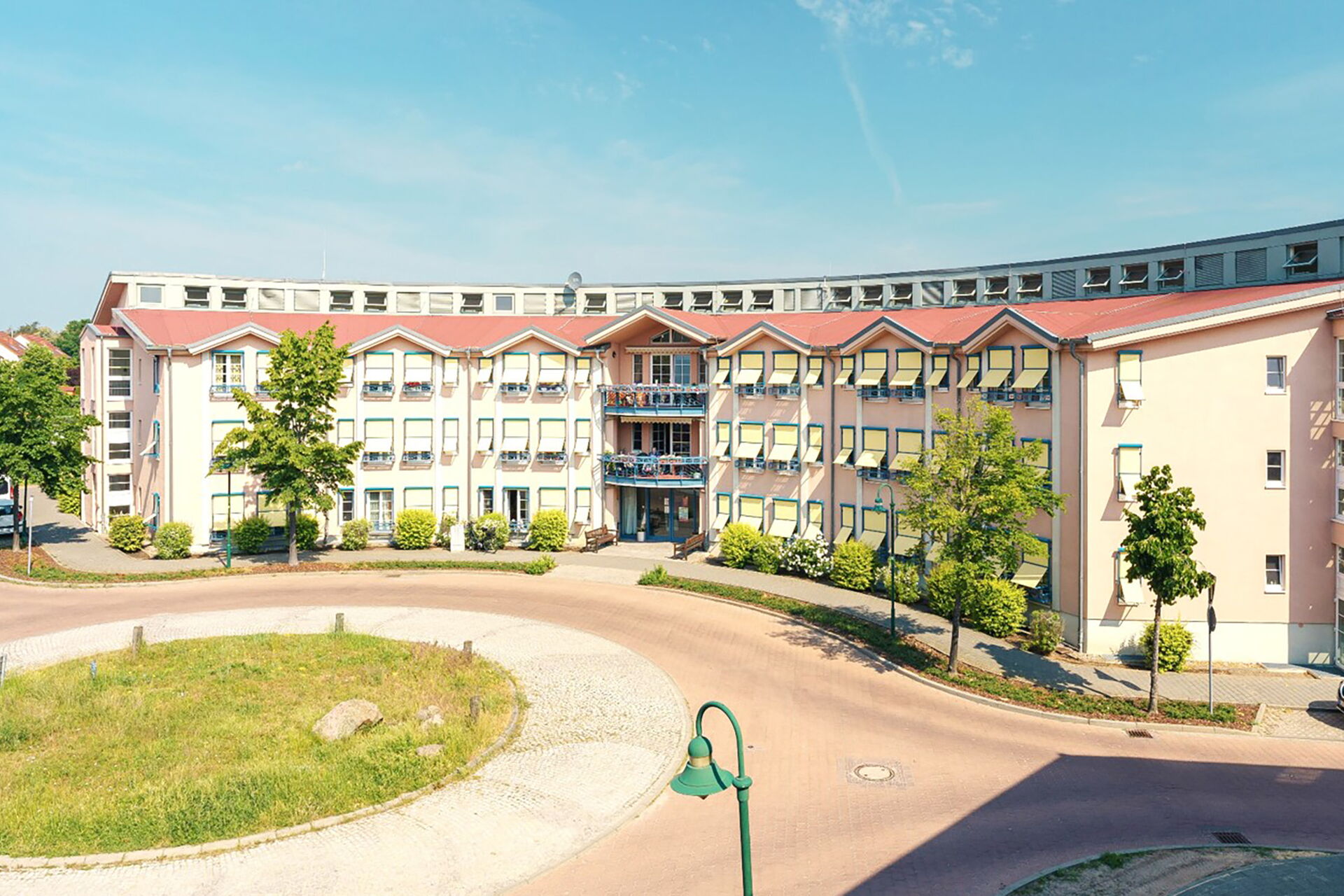 Kreisverkehr, dahinter großer Gebäudekomplex.