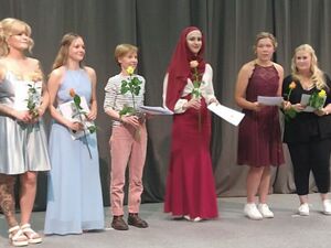 6 Frauen mit Rose und Abschlusszeugnis in der Hand. Frauen sind festlich gekleidet. 4 von ihnen tragen schöne elegante Kleider.