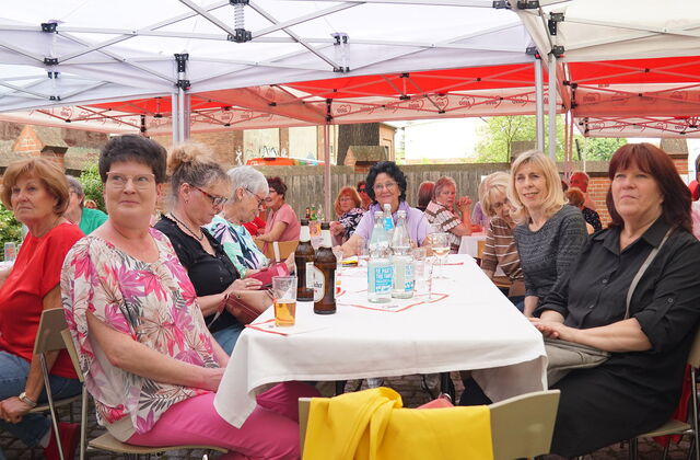 Viele Tische unter Pavillons, an denen viele Frauen sitzen. Auf den Tischen Getränke, Wasser, Bier, Sekt.